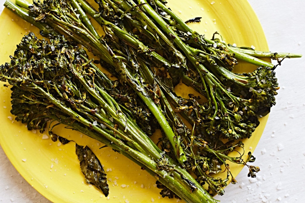 Roasted broccolini on a yellow plate