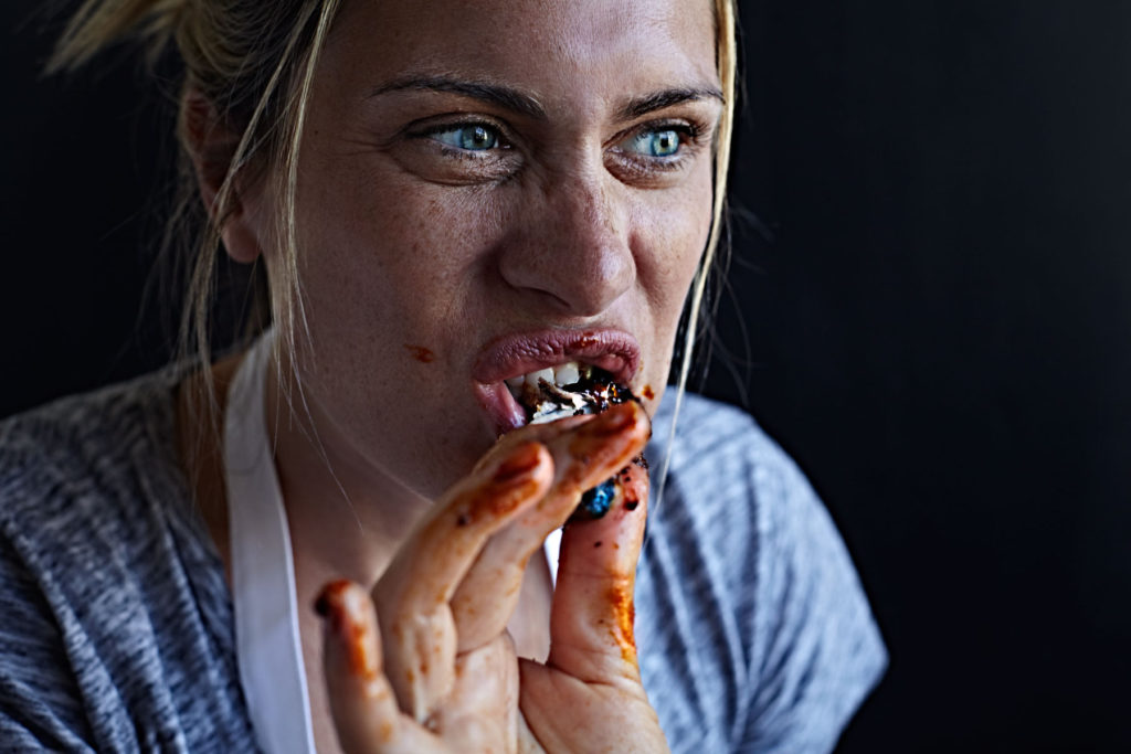 Woman eating meat from fall off the bone baby back ribs.