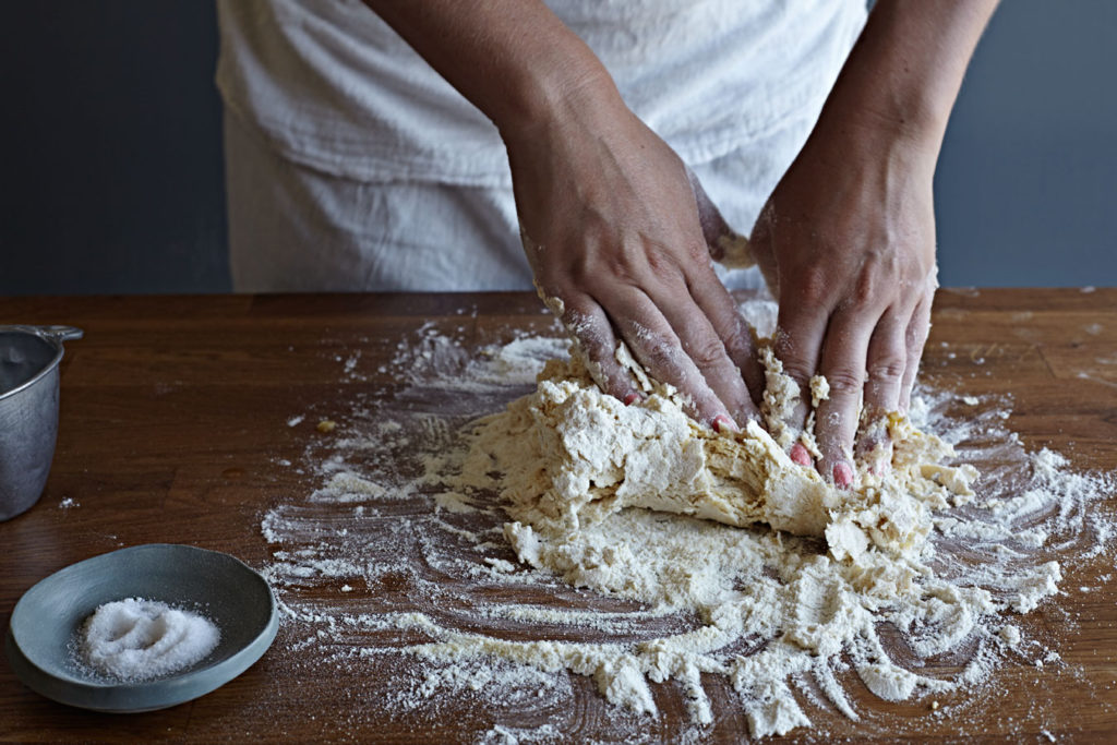 Woman kneading dough to make pasta.