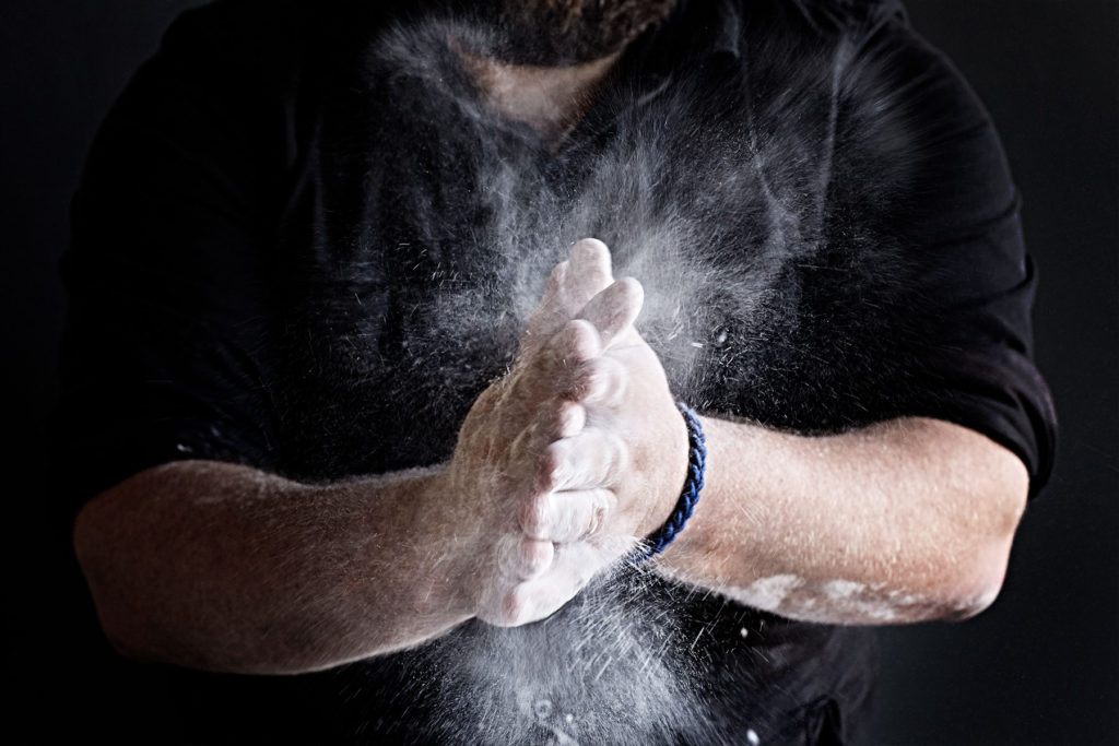 Man's hands clapping flour.