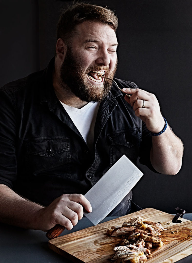 Bearded southern man eating chicken and biscuits.