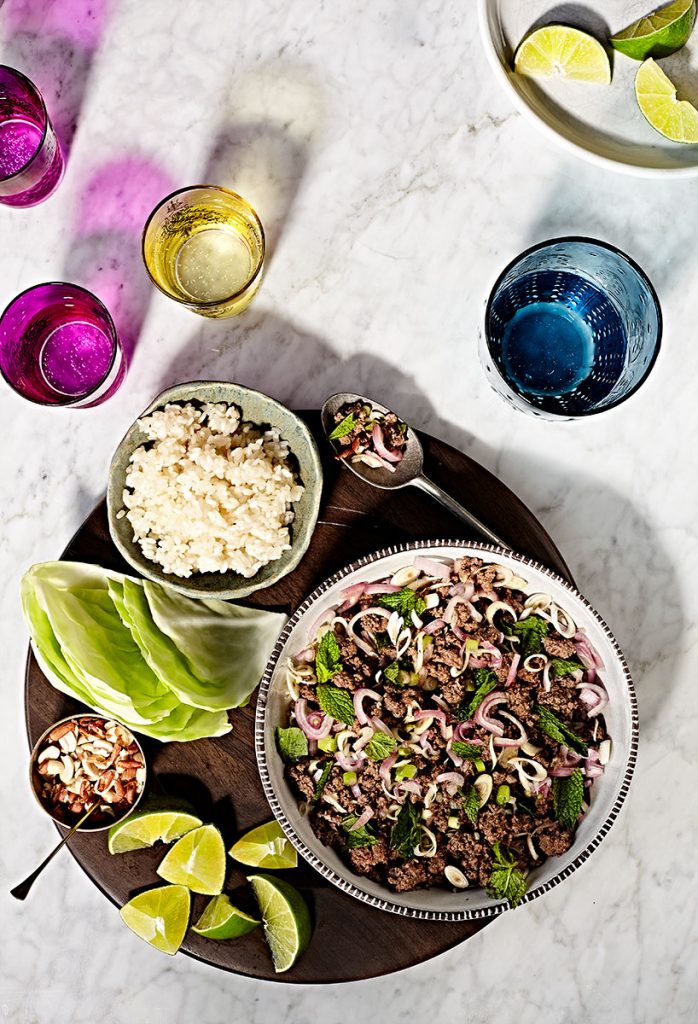Thai beef larb in a bowl with cabbage, peanuts, lime and coconut sticky rice.