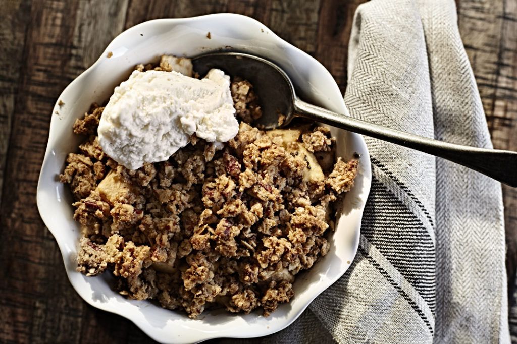 Gluten-free bourbon apple crisp in dish with ice cream.