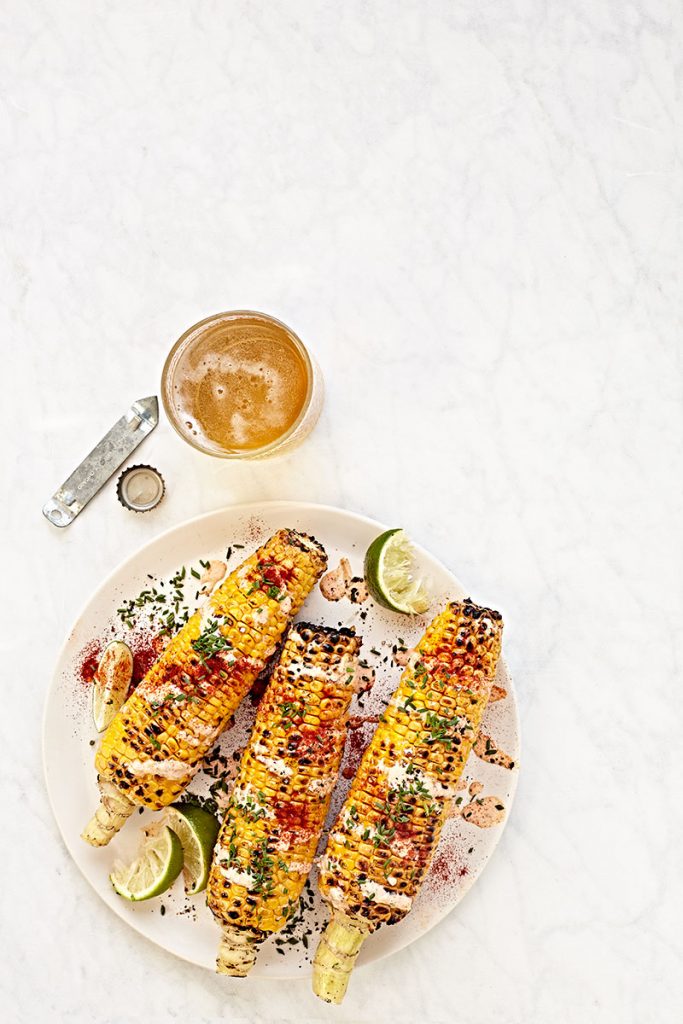 Mexican street corn with cheese, herbs and chili powder.
