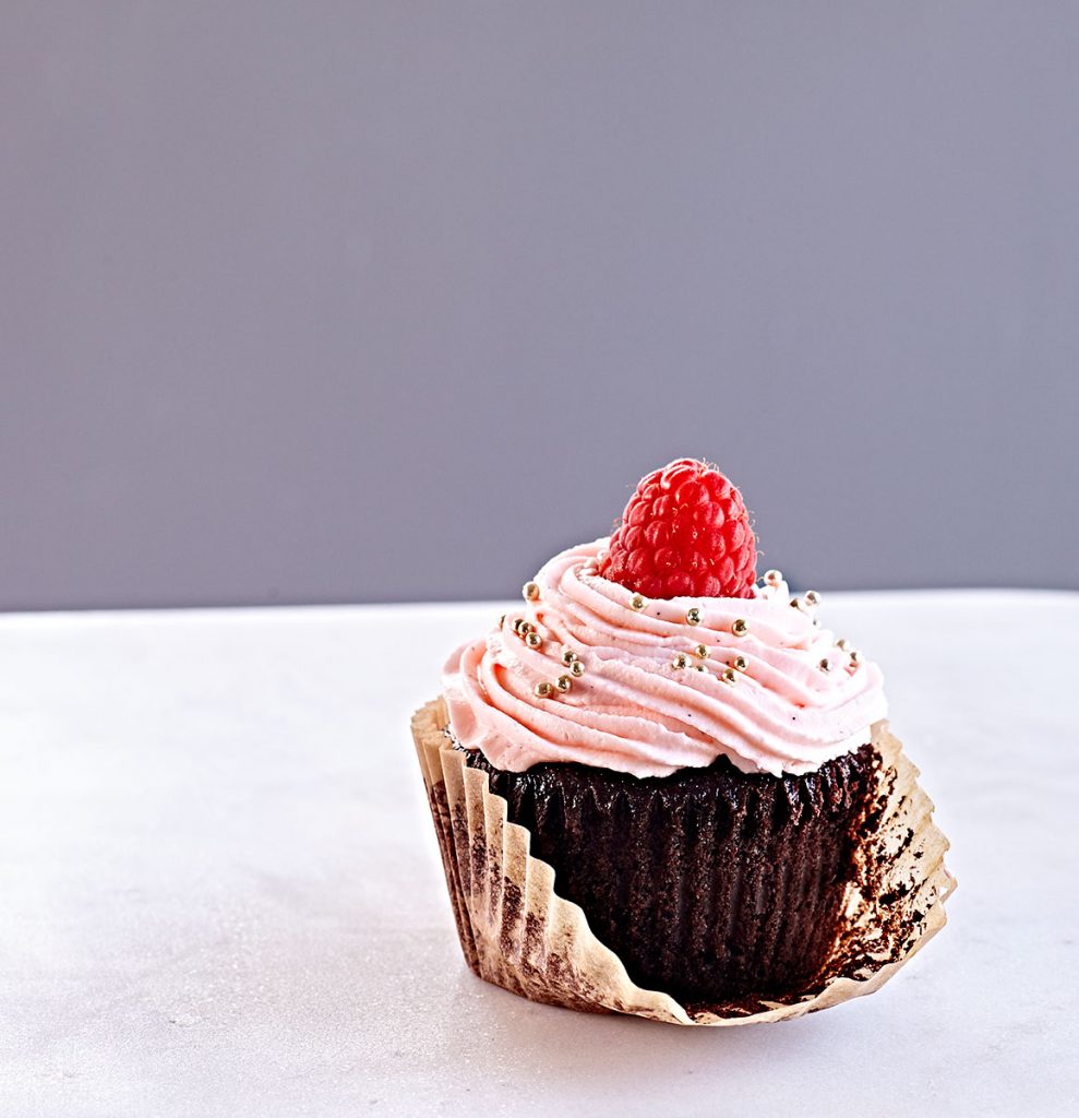 Gluten-free chocolate cupcake with orange blossom whipped cream cheese and shipping cream frosting.