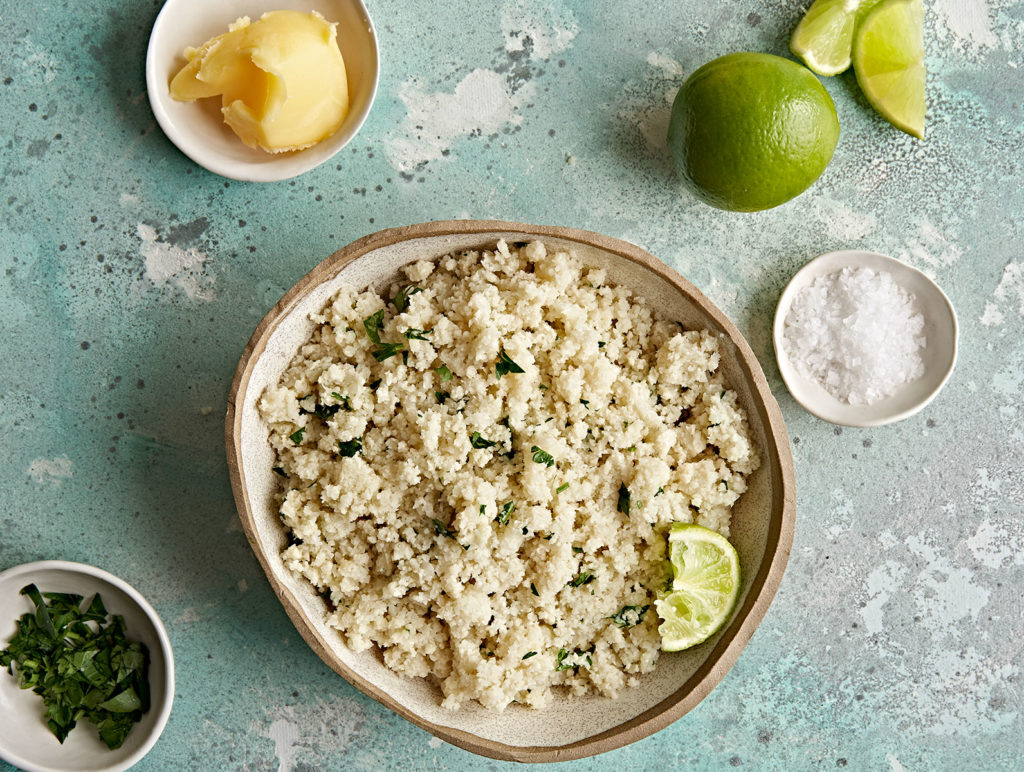 Cauliflower rice in bowl with lime.