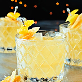 Candied Ginger Bourbon Smash on glasses with twinkling lights.