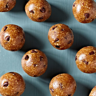 No-bake cookie dough energy balls on a blue table.
