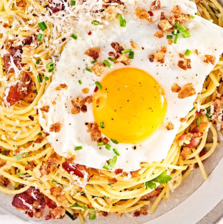 Close-up of Breakfast pasta with a sunny-side up egg.
